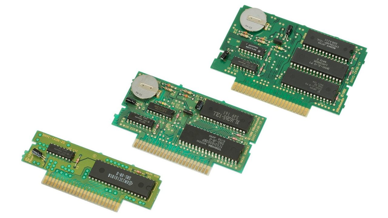 Three Super NES cartridge circuit boards showing edge contacts, chips and a save battery