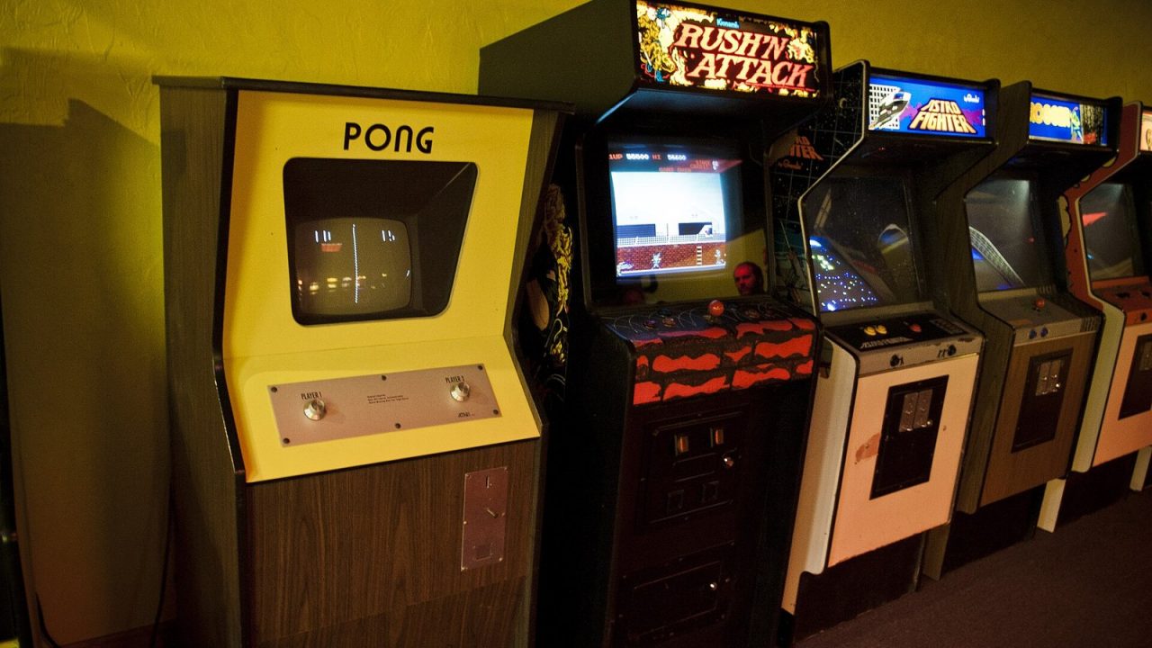 Pong, Rush'n Attack, Astro Fighter and Frogger arcade cabinets standing side by side