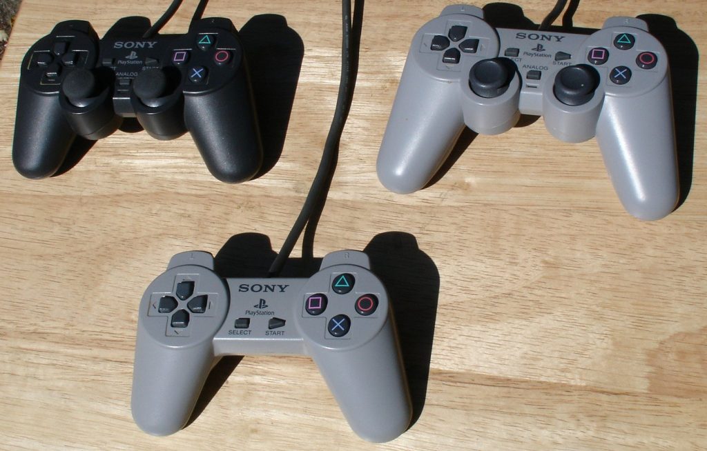 Three PlayStation controllers: original pad, Dual Analog and DualShock