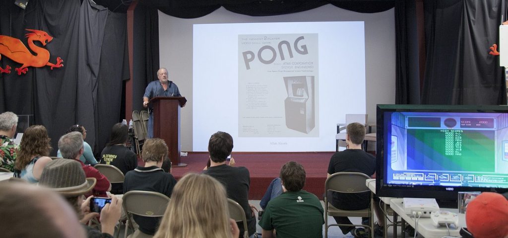 Allan Alcorn holding up the first advertisement for Pong