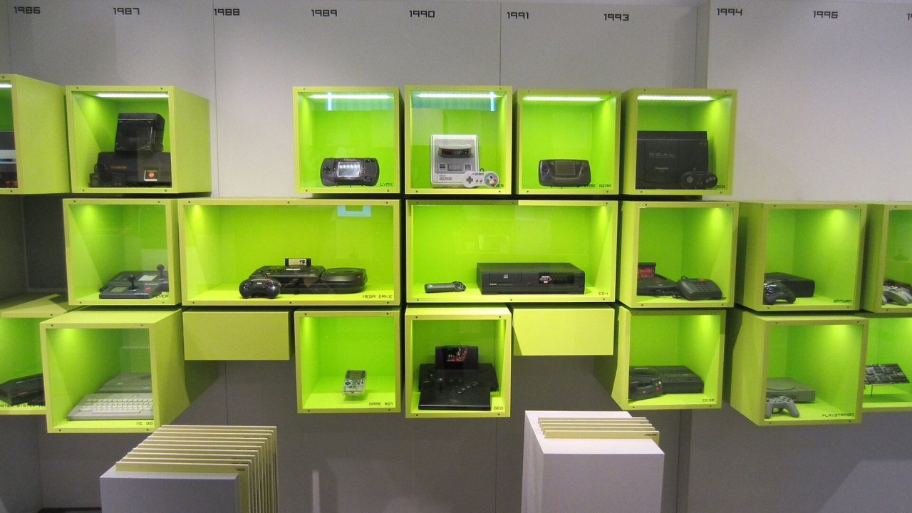 Glass case of 1980s and 1990s game consoles at the Computerspielemuseum in Berlin